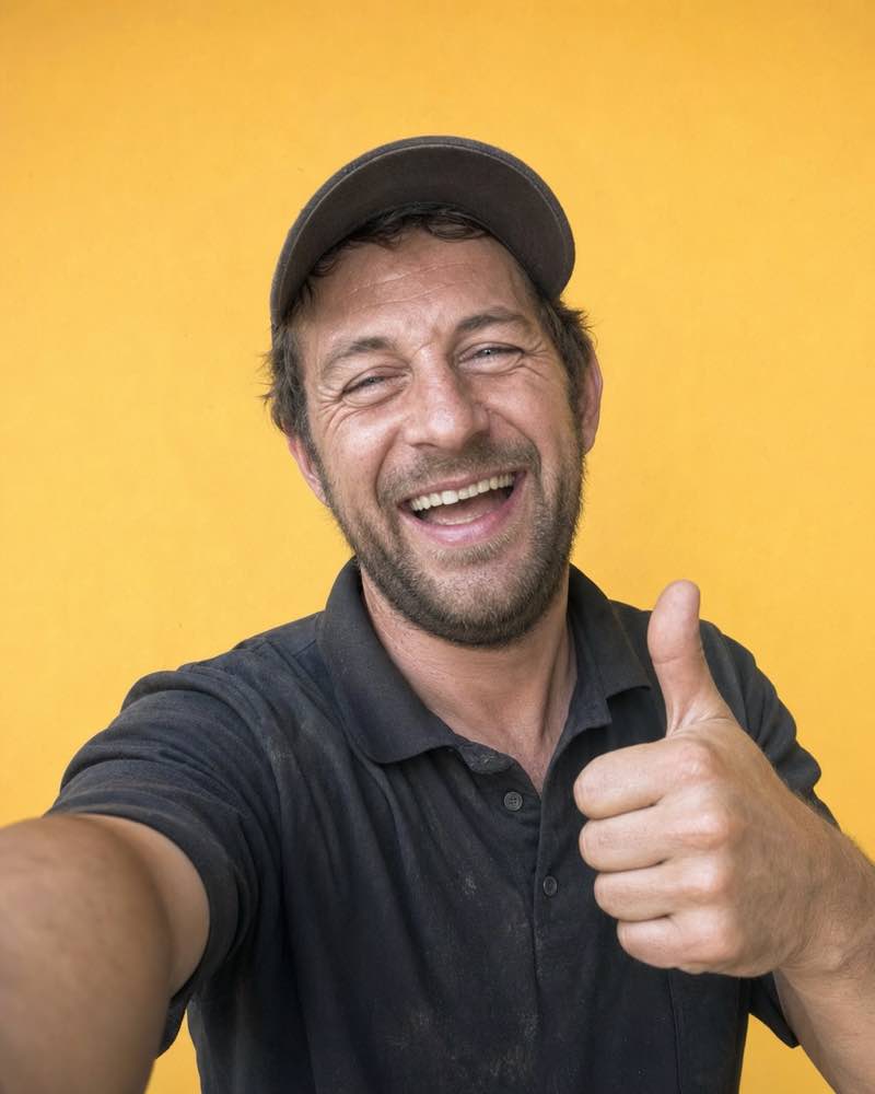 Lachender Mitarbeiter mit Daumen hoch